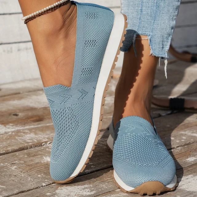 Black slip-on knitted shoes with a white sole