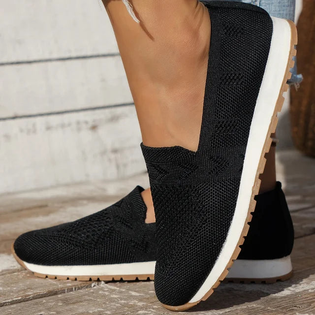Black slip-on knitted shoes with a white sole