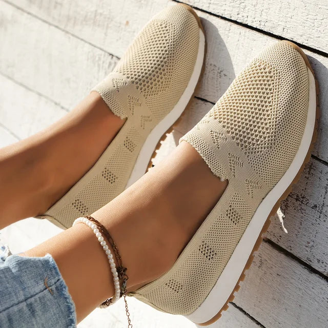 Black slip-on knitted shoes with a white sole