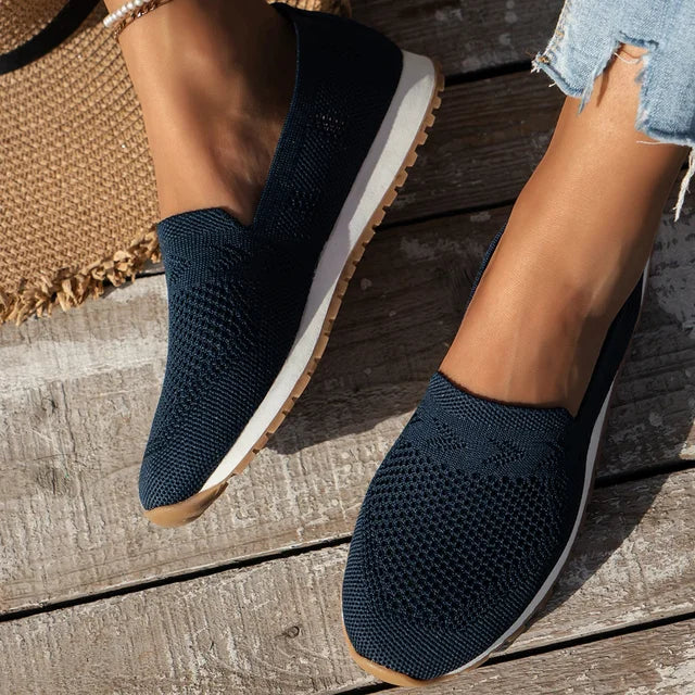 Black slip-on knitted shoes with a white sole